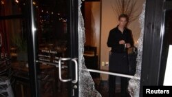 A man looks at broken glass after a riot swept through the area in protest to the election of Republican Donald Trump as President of the United States in Portland, Oregon, Nov. 10, 2016.