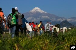 Central American migrants begin their morning trek as part of a thousands-strong caravan hoping to reach the U.S. border, as they face the Pico de Orizaba volcano upon departure from Cordoba, Veracruz state, Mexico, Monday, Nov. 5, 2018.