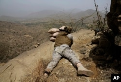 FILE - A Saudi soldier aims his weapon toward the Yemen border in Jizan, Saudi Arabia, April 20, 2015.