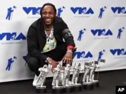 Kendrick Lamar poses in the press room with the awards for best hip hop video, best direction, best cinematography, best art direction, best visual effects, and video of the year for &quot;HUMBLE.&quot; at the MTV Video Music Awards, Aug. 27, 2017, in Inglewood, Ca