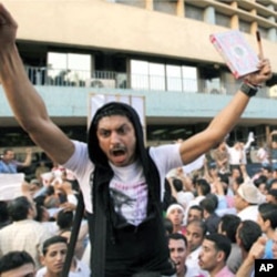A man carries a Koran and a cross during a demonstration by Egyptian Christians and Muslims shouting "Muslims and Christians hand in hand" in front of the Egyptian Television building in downtown Cairo, May 8, 2011