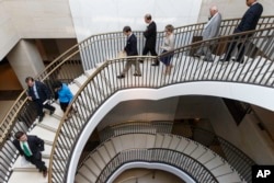 Members of Congress descend to a secure area at the Capitol to meet with national security officials for an intelligence briefing about the decision to swap captive Army Sgt. Bowe Bergdahl for five detainees at Guantanamo Bay, in Washington, June 9, 2014.