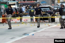 FILE - Federal Bureau of Investigation officials walk past evidence markers near the site of an explosion in the Chelsea neighborhood of Manhattan, New York, Sept. 18, 2016.