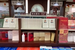 FILE - Uyghur-language copies of writings by Mao Zedong and Chinese President Xi Jinping sit on the shelves of the "ethnic minority language book" section of a bookstore in Aksu, in China's far west Xinjiang region, March 18, 2021.