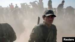 A Syrian Democratic Forces (SDF) fighter stands at a cemetery during a funeral for SDF fighters killed by Islamic State militants in Raqqa, Syria, June 23, 2017.
