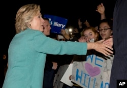 FILE - Democratic presidential nominee Hillary Clinton greets people outside on the street as she leaves a fundraiser in Piedmont, California, Aug. 23, 2016.