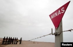 FILE - Chilean army mine sweepers stand next to a mine field during a demonstration of the removal of land mines at the Chacalluta Airport in Arica, northern Chile, Aug. 3, 2004.