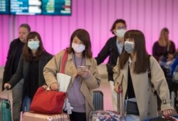Para penumpang menggunakan masker untuk melindung dari virus corona saat tiba di Bandara Internasional Los Angeles, California, 22 Januari 2020.