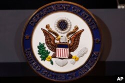 The seal of the State Department is seen on the podium as Secretary of State Mike Pompeo makes a statement about refugees to the media, Sept. 17, 2018, at the State Department in Washington.