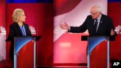 Democratic presidential candidate Sen. Bernie Sanders, right, gestures toward former Secretary of State Hillary Clinton during a democratic presidential primary debate at the Gaillard Center, in Charleston, S.C., Jan. 17, 2016.