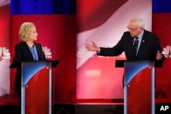 Democratic presidential candidate Sen. Bernie Sanders, right, gestures toward former Secretary of State Hillary Clinton during a democratic presidential primary debate at the Gaillard Center, in Charleston, S.C., Jan. 17, 2016.