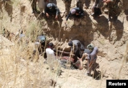 Villagers collect the dead bodies of civilians who were killed by insurgents at Mirza Olang village, in Sar-e Pul province, Afghanistan Aug. 15, 2017.