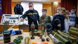 Un agente de la policía muestra explosivos a escolares durante una lección de seguridad organizada por la policía en una escuela de Kiev, Ucrania, el 27 de enero de 2022. Las autoridades de la ciudad están entrenando a civiles en medio de temores de una posible invasión de Rusia.