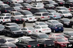 Shoppers return to their car at a mall in King of Prussia, Pa., Dec. 8, 2016. Retailers are pushing promotions and other enticements for the final stretch of the holiday season as new numbers show that shoppers are spending at a decent, but a tad slower than last year.