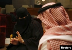 Saudi woman Fawzia al-Harbi, a candidate for local municipal council elections, gestures to one of her chaperones at a shopping mall in Riyadh November 29, 2015.