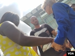 A member of the Billy Graham Evangelistic Association leads an impromptu prayer with two locals at Orlando's victim memorial, June 16, 2016. (Photo: A. Arabasadi/VOA)