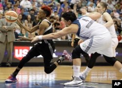 San Antonio Stars guard Danielle Robinson, left, pushes the ball through the Minnesota Lynx defense in a game in Minneapolis, July 3, 2014.