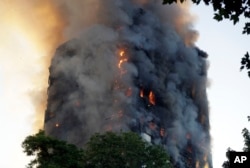 Smoke and flames rise from a building on fire in London, June 14, 2017.