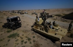 Iraqi army members and Shi'ite Popular Mobilization Forces (PMF) gather in Al-Al-Fateha military airport south of Hawija, Iraq, Oct. 2, 2017.