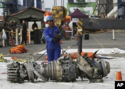 Para petugas memindahkan mesin Lion Air JT610 untuk penyelidikan di Jakarta, 4 November 2018.