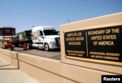 FILE - A truck of the Mexican company Olympics crosses the Puente Internacional Comercio Mundial (World Trade International Bridge) while approaching the border crossing into the U.S., in Laredo.