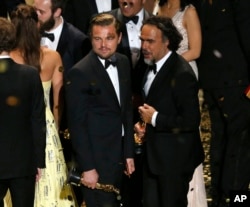 Director Alejandro Inarritu (R) and actor Leonardo DiCaprio hold their Oscars after the end of the awards ceremony at the 88th Academy Awards in Hollywood, California, Feb. 28, 2016.