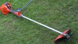 A grass cutter sits on a lawn.