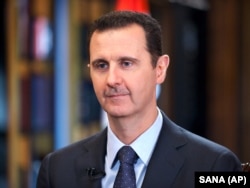 FILE - Syrian President Bashar Assad speaks during an interview with Venezuela's state-run Telesur network, in Damascus, Syria.