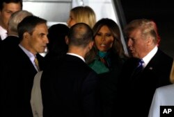 President Donald Trump and first lady Melania Trump are greeted by officials upon their arrival in Warsaw, Poland, Wednesday, July 5, 2017.