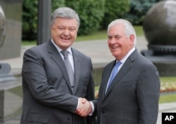 Ukrainian President Petro Poroshenko, left, and U.S. Secretary of State Rex Tillerson shakes hands before a meeting in Kyiv, Sunday, July 9, 2017.