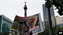A street vendor hawks a newspaper emblazoned with an image of Donald Trump with a clown's nose and a headline that reads in Spanish: "We're screwed!" in Mexico City, Nov. 9, 2016.
