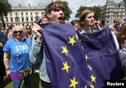 People hold flags during a 'March for Europe' demonstration against Britain's decision to leave the European Union, in central London, Britain, July 2, 2016.