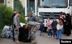 FILE - Lebanese security officers check the luggage of Syrian refugees returning to Syria, in Beirut, Lebanon, Dec. 6, 2018.