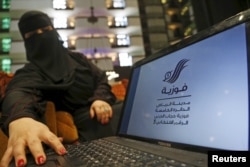 Saudi woman Fawzia al-Harbi, a candidate for local municipal council elections, shows her candidate biography at a shopping mall in Riyadh, Saudi Arabia, Nov. 29, 2015.