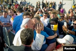 Pope Francis engages well wishes as he kisses a child after arriving at John F. Kennedy International Airport in New York, Sept. 24, 2015.