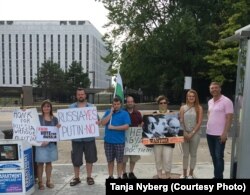 FILE - Maria Butina stands outside the Russian embassy in Washington during a protest of Duma elections in September 2016.