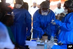 Healthcare workers from the World Health Organization prepare to give an Ebola vaccination to a front line aid worker in Beni Democratic Republic of Congo, Friday, Aug 10, 2018.