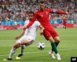 Portugal's Cristiano Ronaldo, right, and Iran's Omid Ebrahimi challenge for the ball during the group B match between Iran and Portugal at the 2018 soccer World Cup at the Mordovia Arena in Saransk, Russia, June 25, 2018.