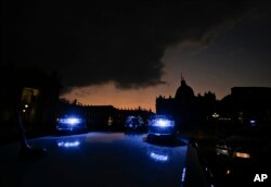 Carabinieri (Italian paramilitary police) car's blue lights flash in front of St. Peter's Basilica, in Rome, Italy, Dec. 4, 2015.