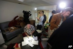 Reporters and photographers crowd into the living room of an apartment in Redlands, Calif., shared by San Bernardino shootings suspects Syed Farook and his wife, Tashfeen Malik, Dec. 4, 2015.