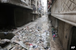 FILE - Children walk down a street in Aleppo, Syria, Feb. 11, 2016.
