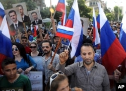 This photo from the Syrian official news agency SANA shows Syrians rallying in front of the Russian Embassy in Damascus to show their thanks to Russia for its intervention in Syria, Oct. 13, 2015.