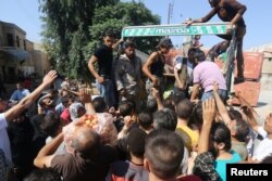 People gather to buy fresh produce that was brought into rebel held areas of Aleppo by private traders from a newly opened corridor that linked besieged opposition held eastern Aleppo with western Syria that was captured recently by rebels, in Aleppo, Aug. 11, 2016.