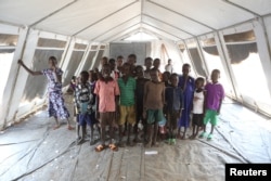 Children, who fled fighting in South Sudan, stand inside a tented classroom at the Bidibidi refugee resettlement camp near the border with South Sudan, in northern Uganda, Dec. 7, 2016.