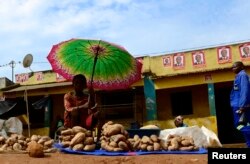 FILE - A vendor displays wares for sale in the central market in Gorongosa, Mozambique, a country with a booming economy yet growing inequality and poverty.