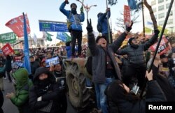 People react after impeachment vote on South Korean President Park Geun-hye was passed, in front of the National Assembly in Seoul, South Korea, Dec. 9, 2016. The sign reads "Arrest Park Geun-hye."