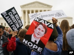 Protesters in front of the Supreme Court hold signs with an image of Judge Brett Kavanaugh that reads "Kava Nope" and "We Believe Christine Blasey Ford" in Washington, Sept. 24, 2018.