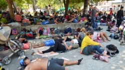 Integrantes de una caravana de migrantes que avanza por México descansan en un parqie de Chahuites el 8 de noviembre de 2021.