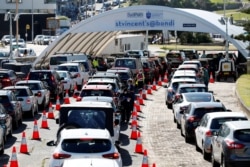 FILE - People queue at a COVID-19 testing clinic as the Omicron variant of the coronavirus continues to spread in Sydney, Australia, Dec. 30, 2021.