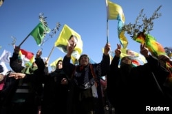 People gesture during a protest against the Turkish attacks on Afrin in Qamishli, Syria, Jan. 30, 2018.
